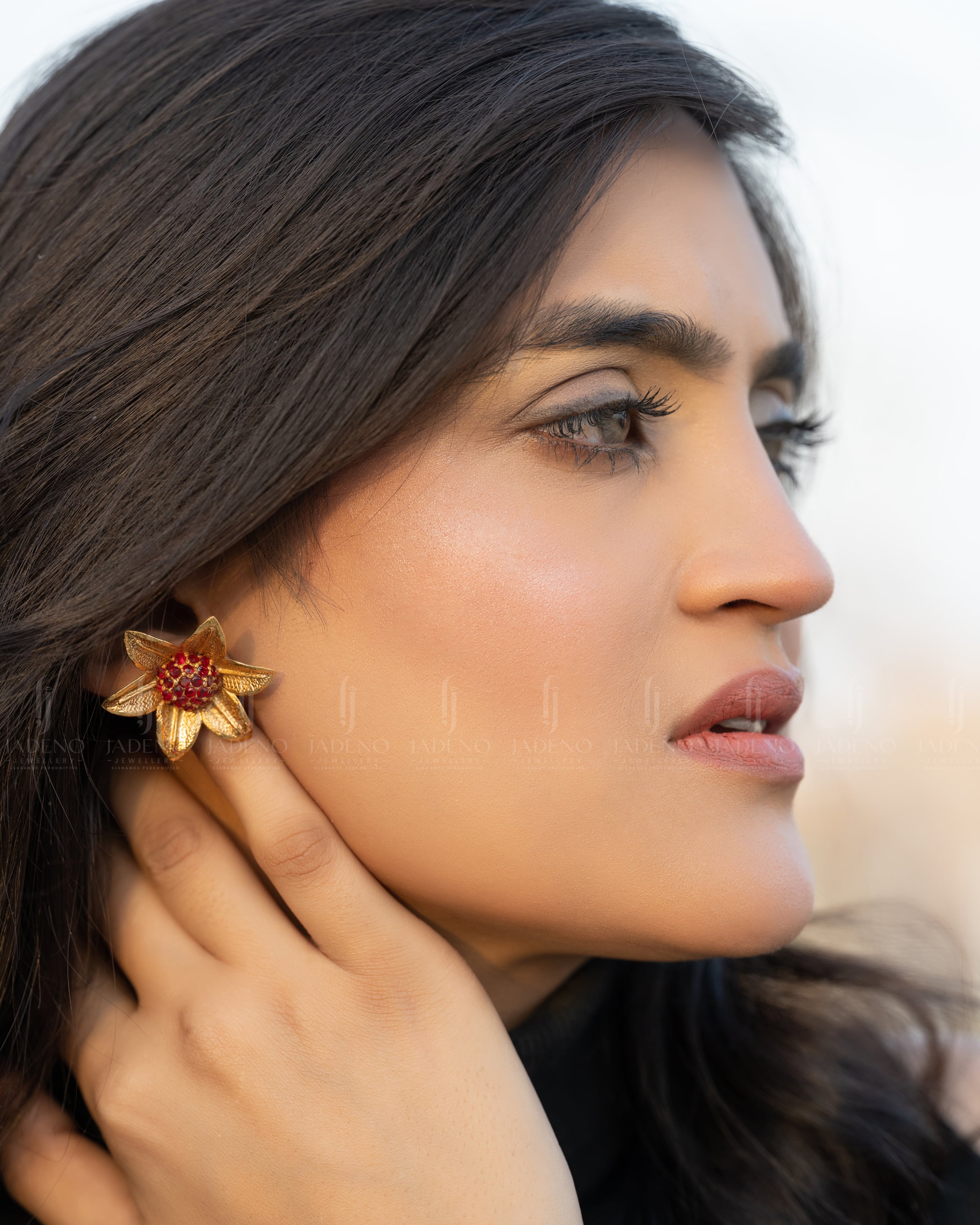 "Model wearing Ruby Dazzling Polki flower stud earrings with golden petals and a sparkling center. Perfect for formal and festive occasions. Available at JADENO"