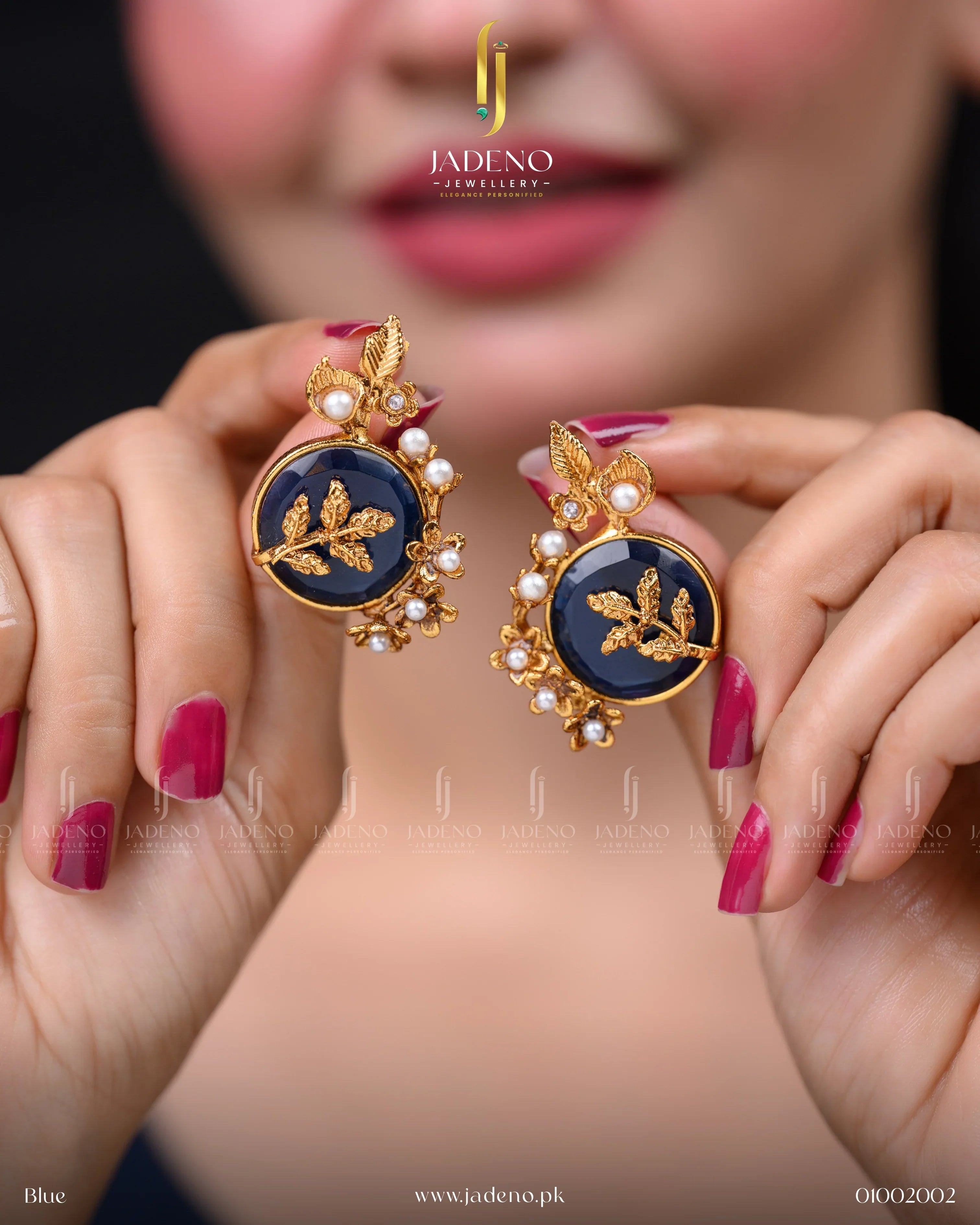 "Hands holding artificial stone earrings with deep blue center and pearl detailing"