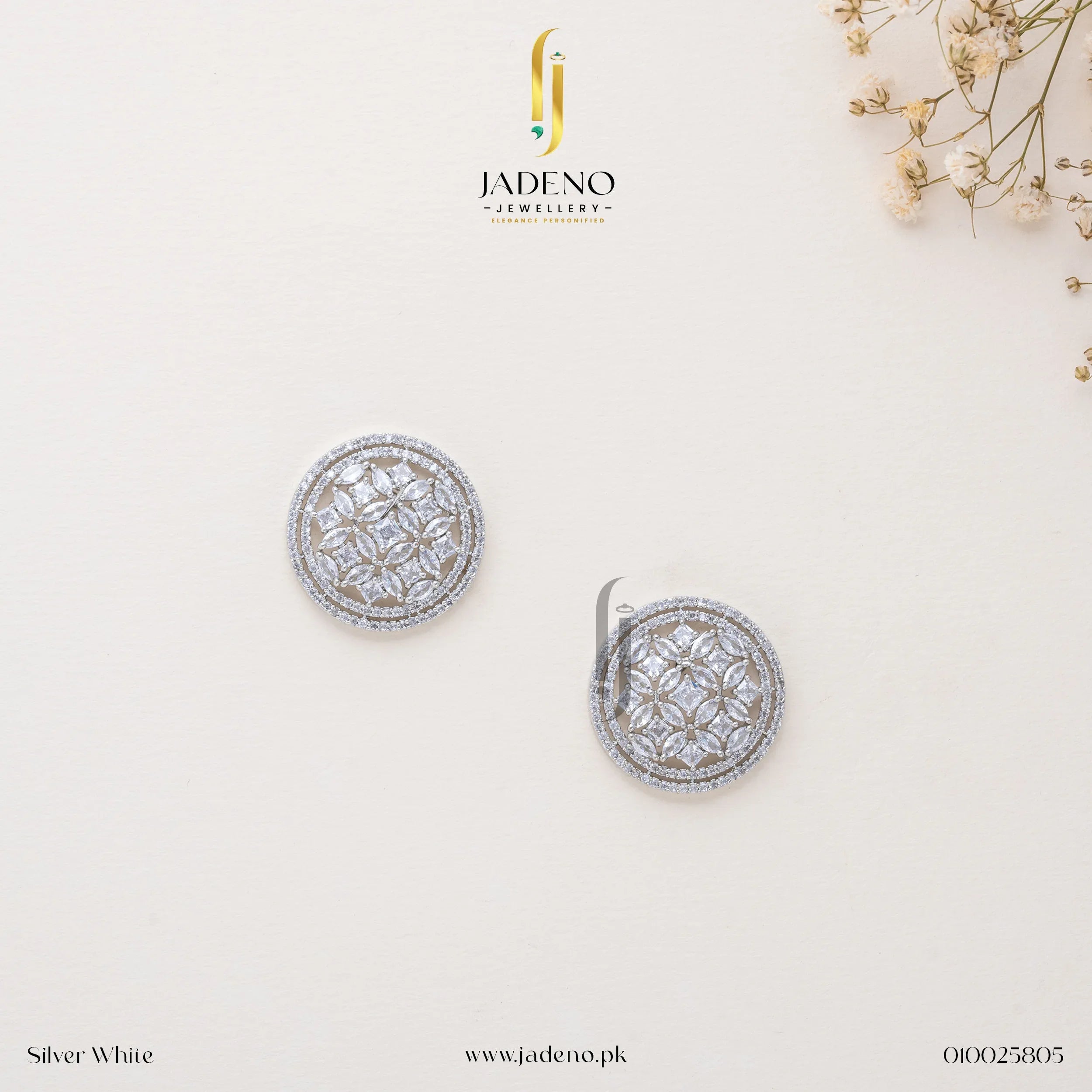 "Elegant silver-white American diamond stud earrings with intricate circular detailing, perfect for formal and special occasions. Available at JADENO."
