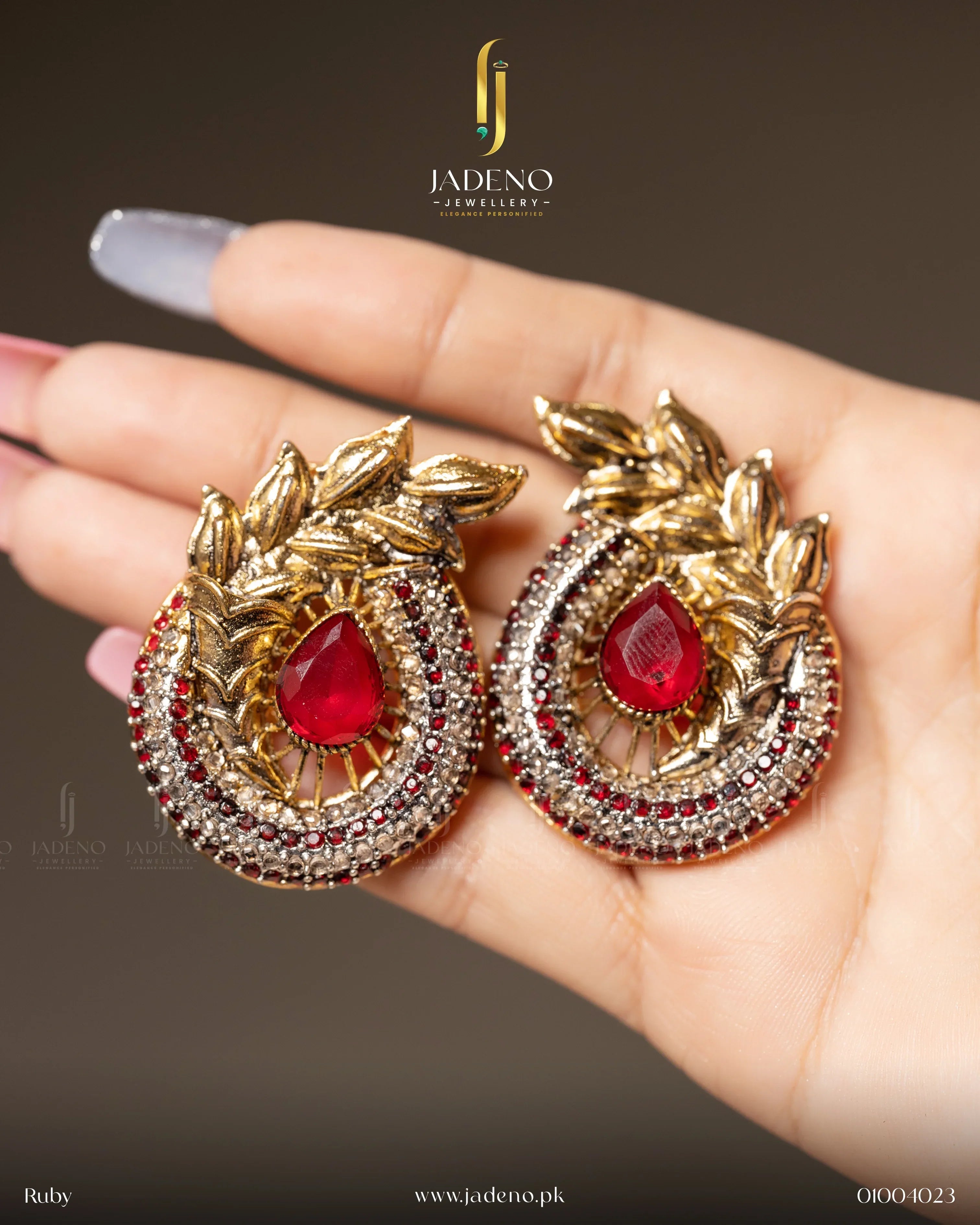 "Elegant blue-colored Ancient Leaf earrings with gold detailing and sparkling gemstones, worn on the ear. Perfect for formal occasions. Available at JADENO"