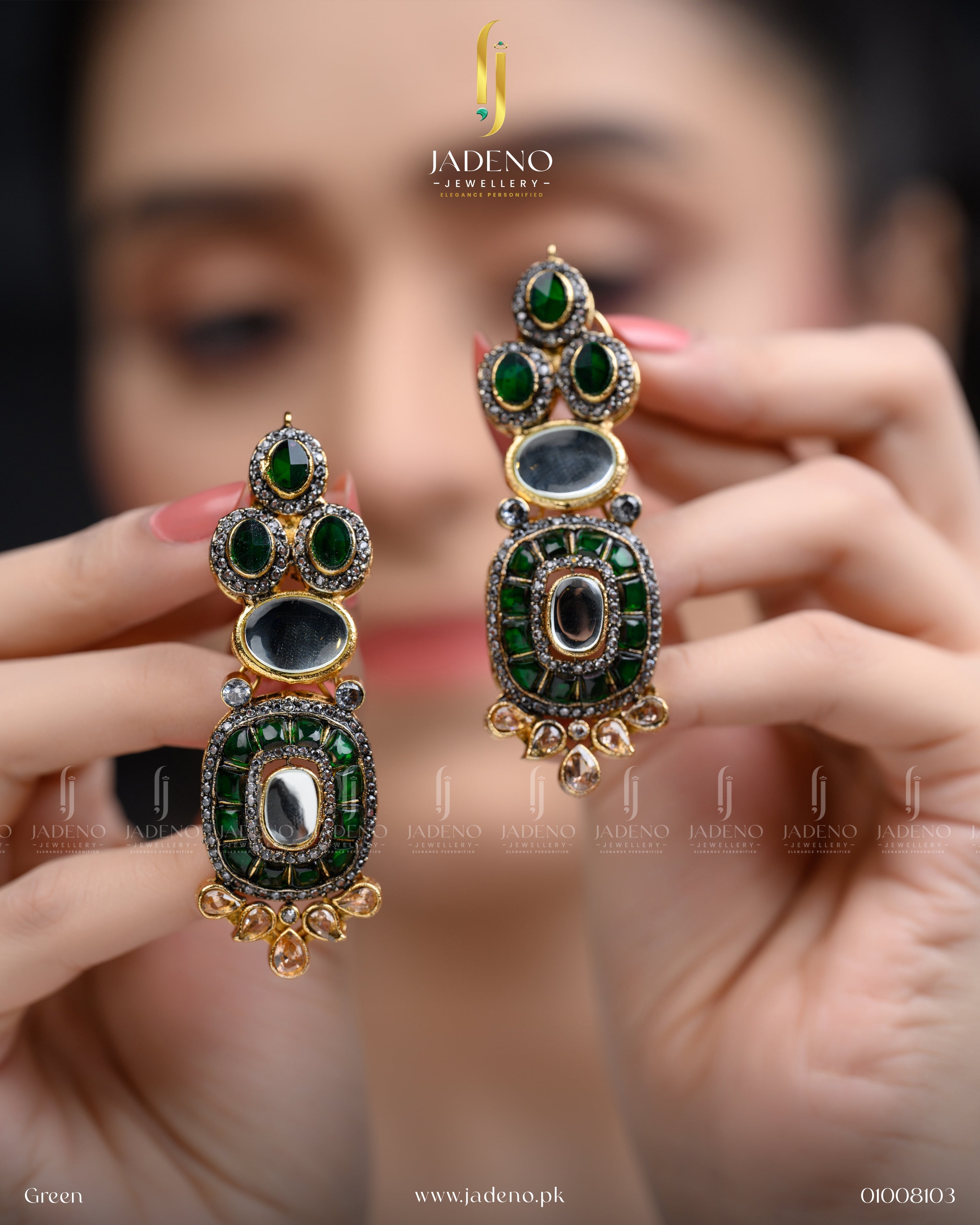 "Hands holding green stone cut earrings with ornate gold detailing"