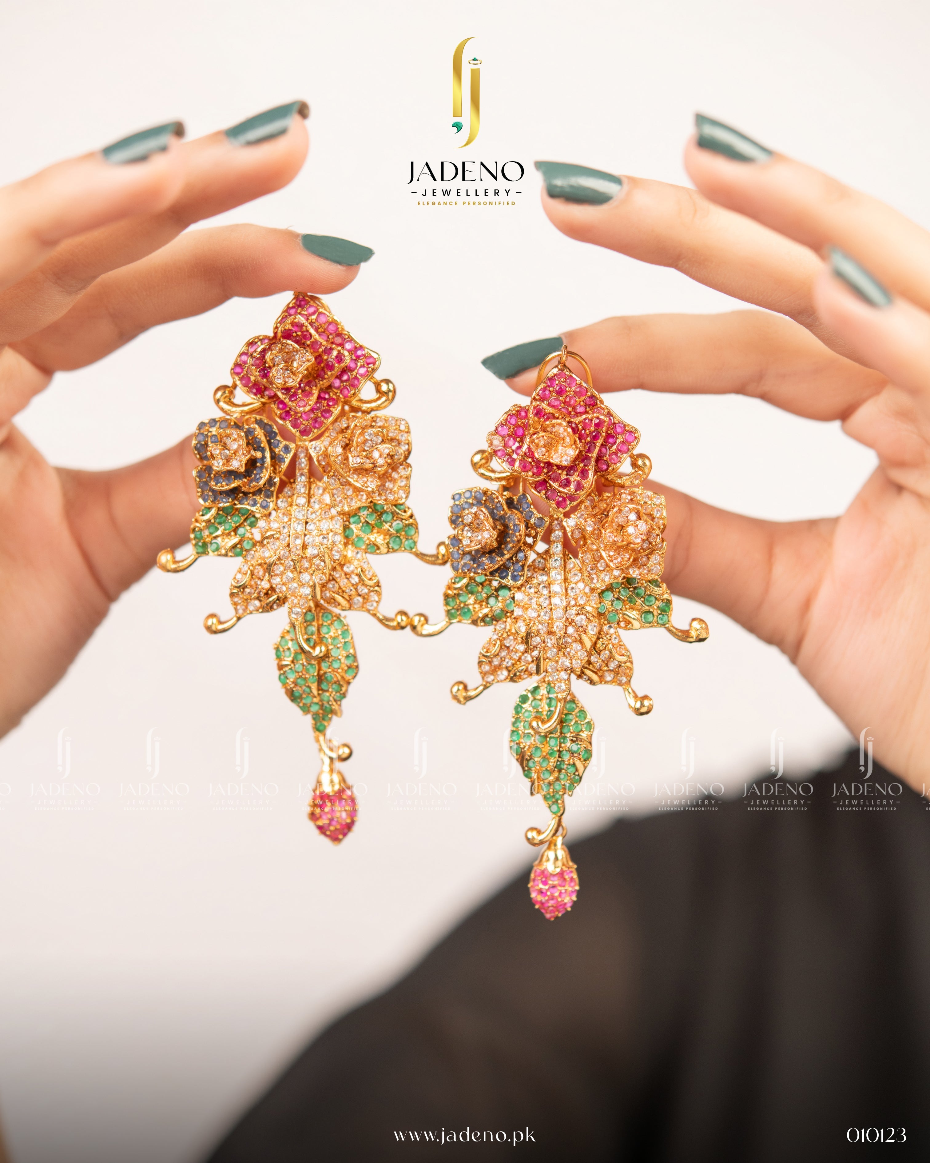 "Stylish multi colored floral pasha earrings with green and pink stones held in hands"