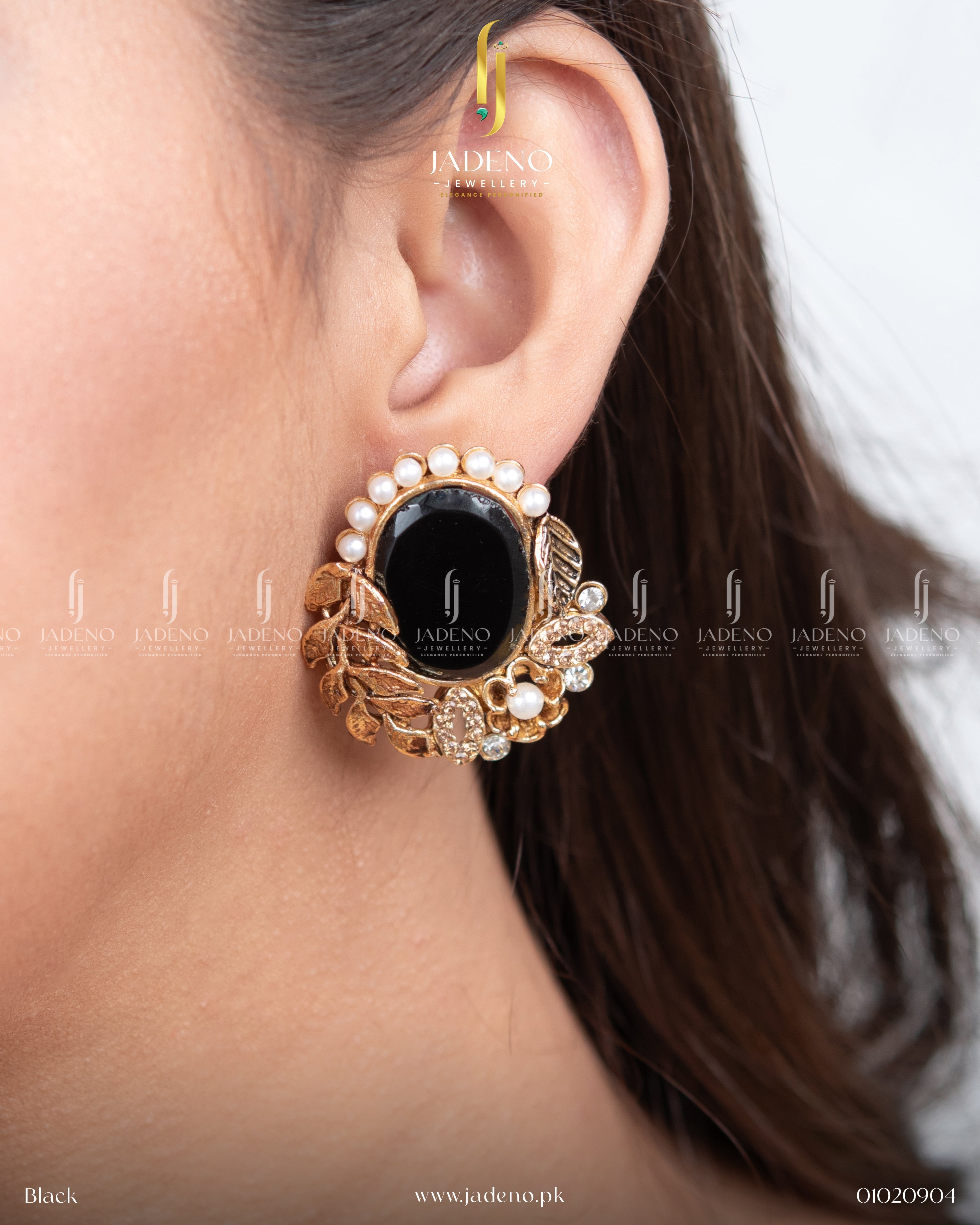 "Black oval stone leaf cut earrings worn on ear with gold detailing"