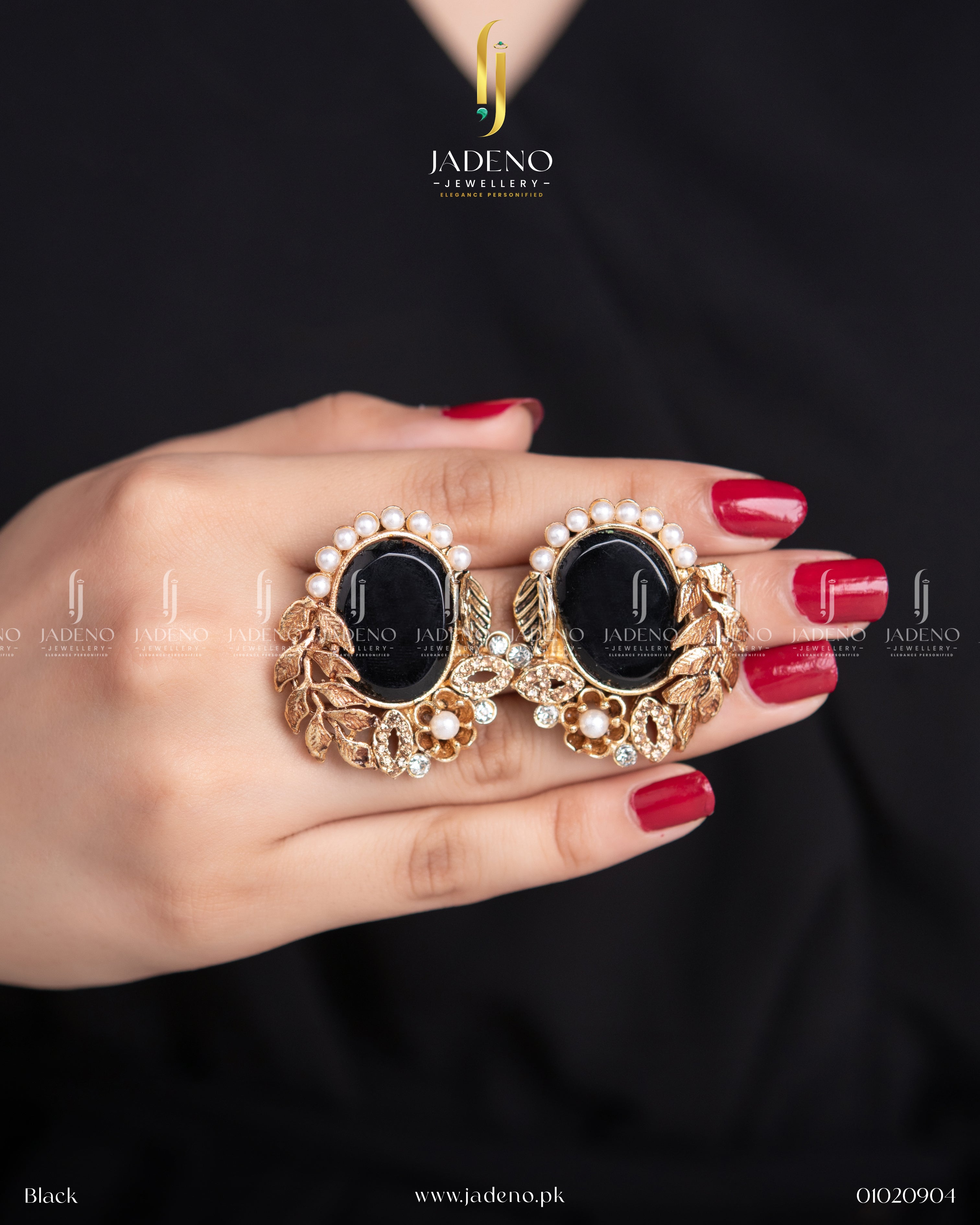 "Pair of black stone leaf cut earrings displayed in hand"