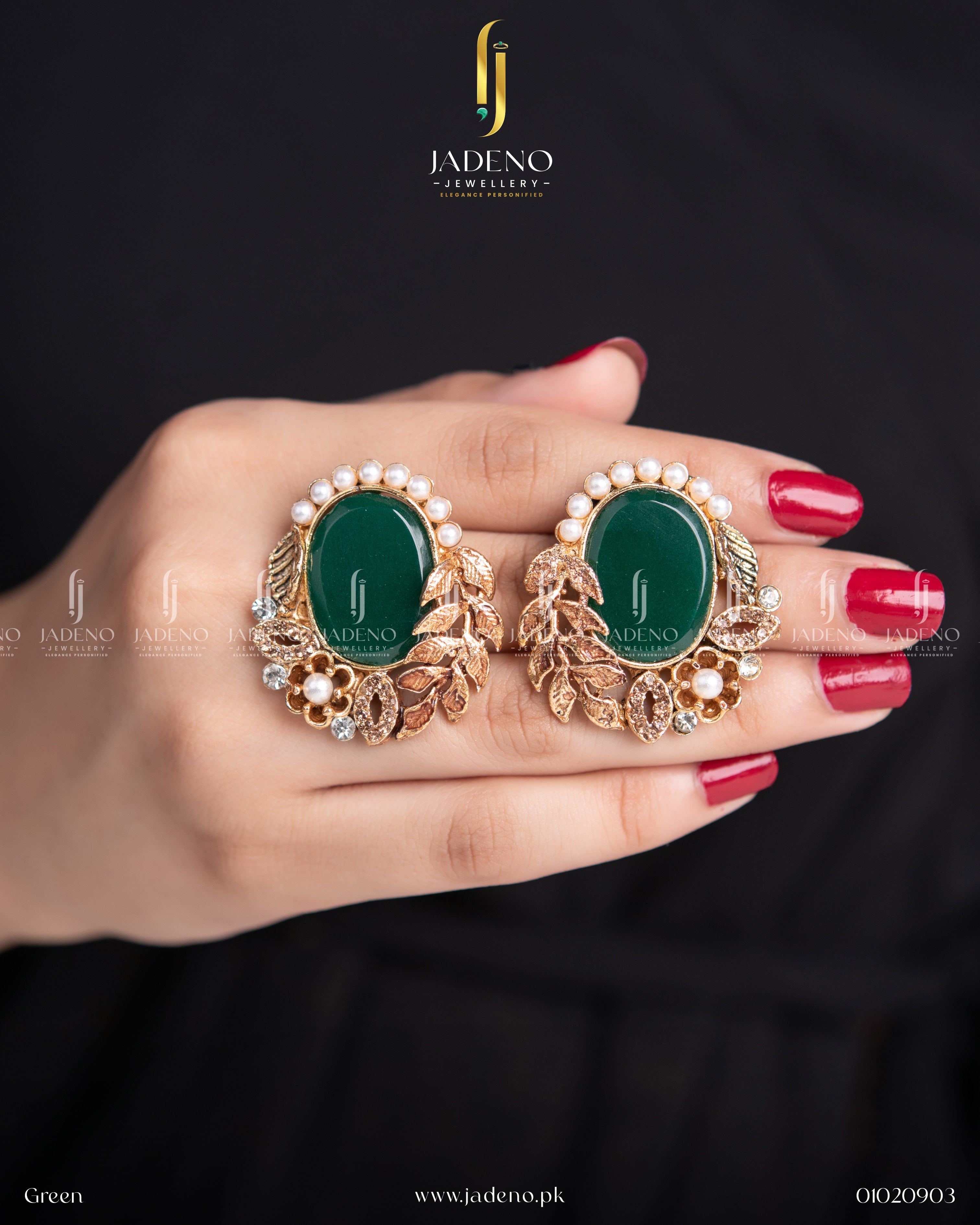 "Green stone leaf cut earrings with pearl accents shown in hand"