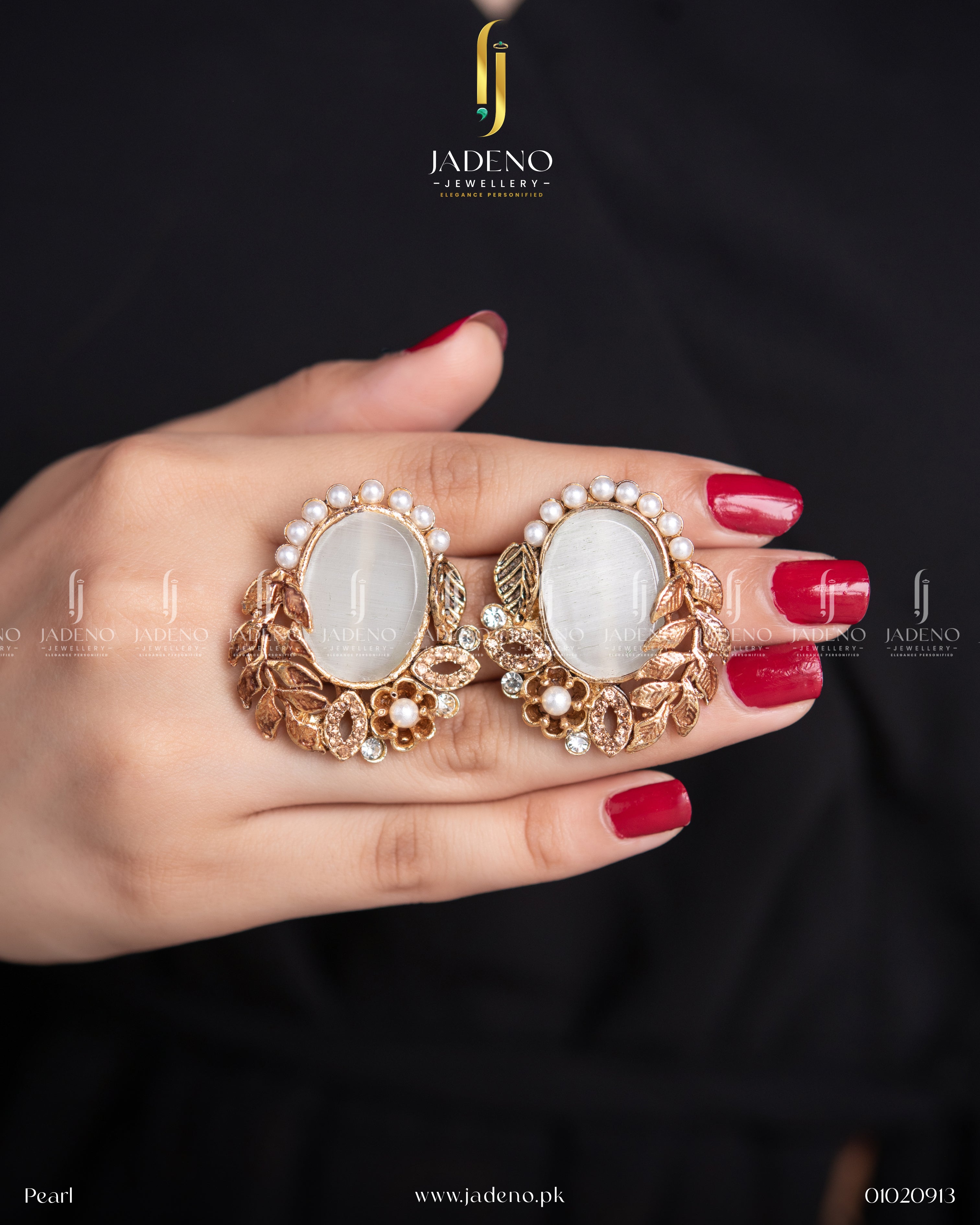 "Hands holding white leaf cut earrings with pearl border and gold leaf accents"